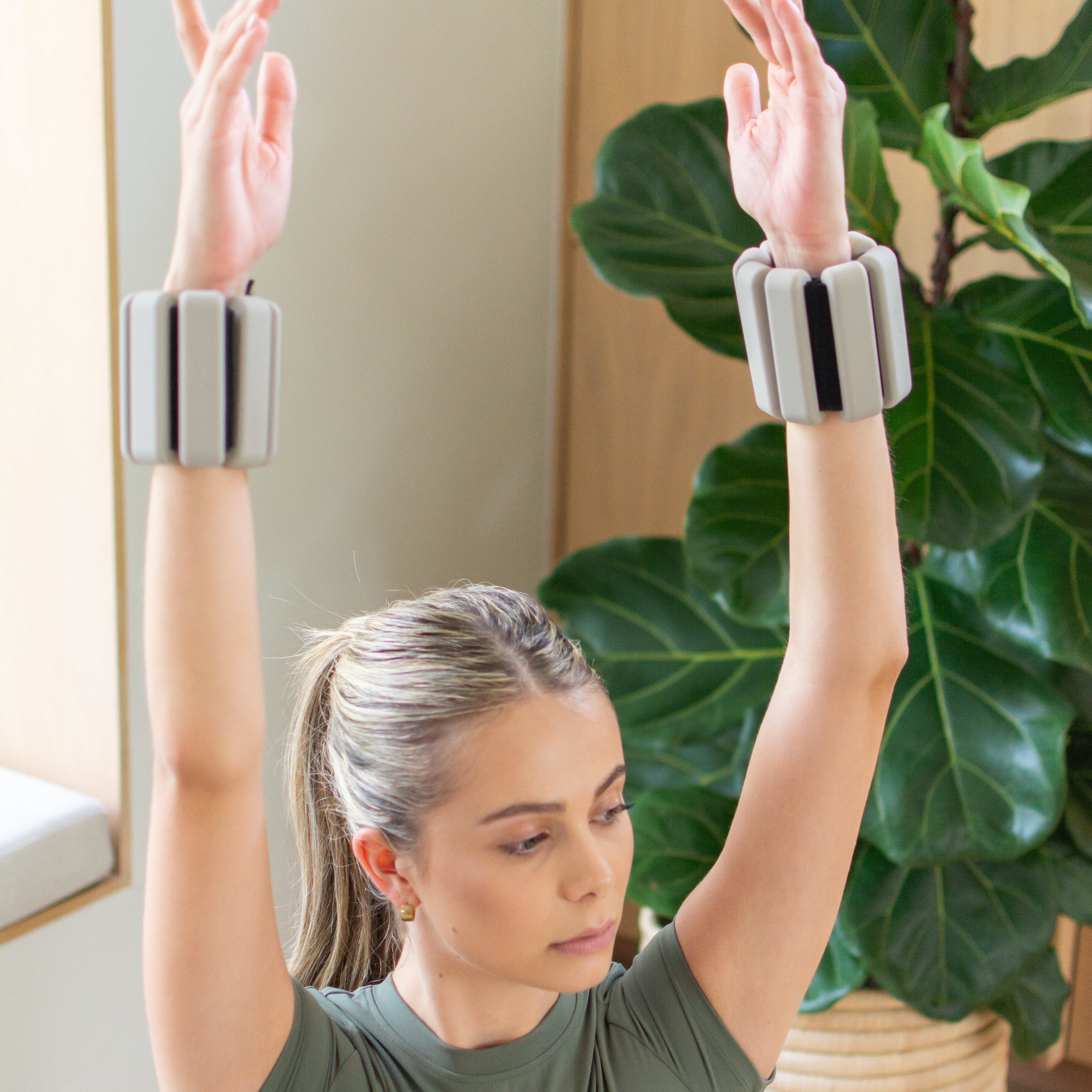 Woman exercising with nulo arm weights in a home setting